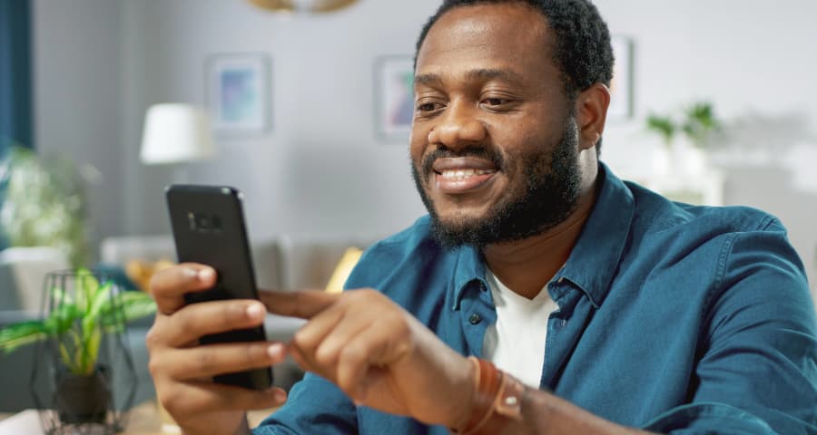 Man sitting down navigating an app on his cell phone